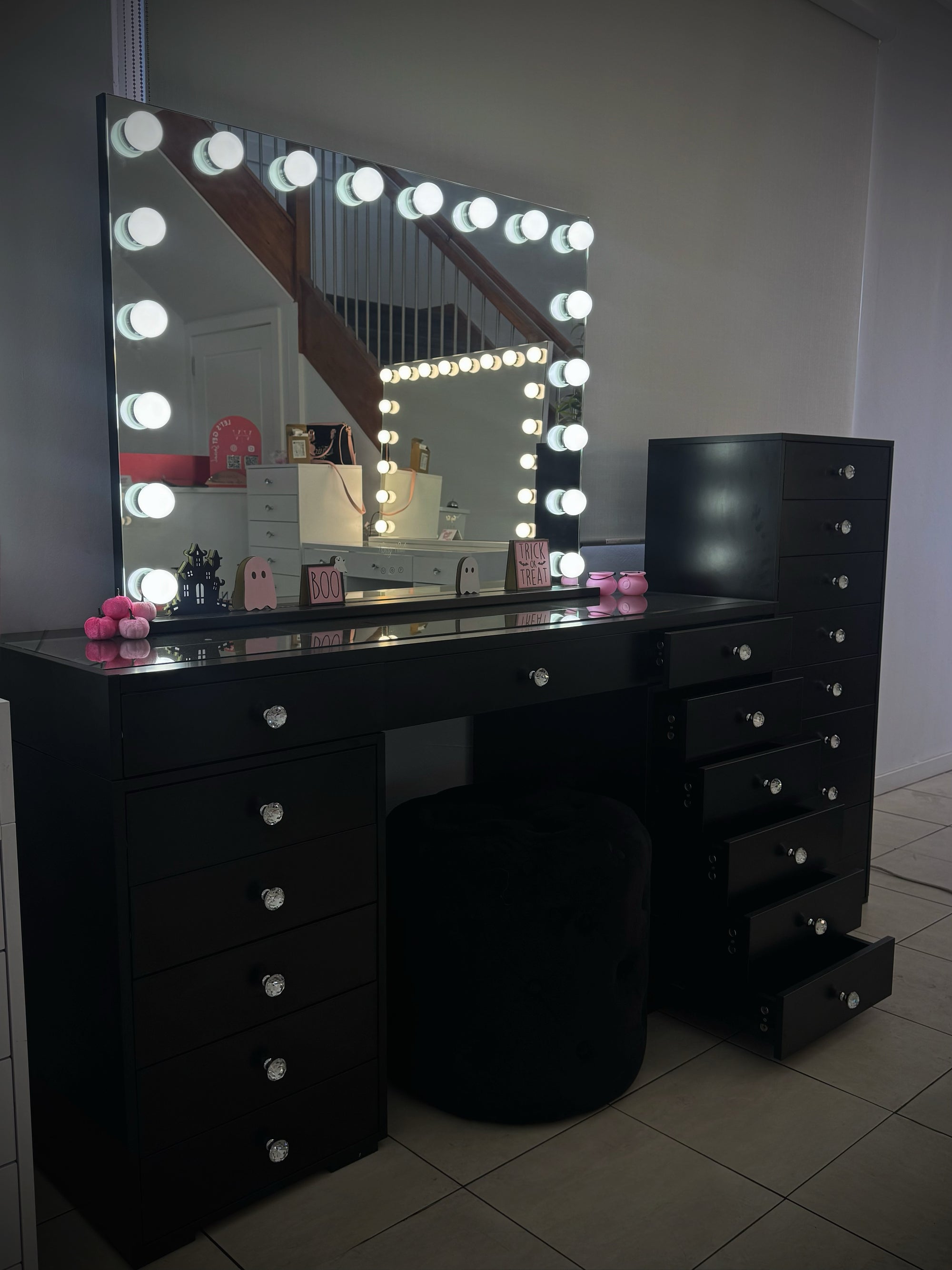 Luxury black makeup vanity package with a Black Out Beauty vanity, Black Luna Luxe Hollywood Mirror, matching drawer towers and ottoman for modern beauty rooms and bedrooms.
