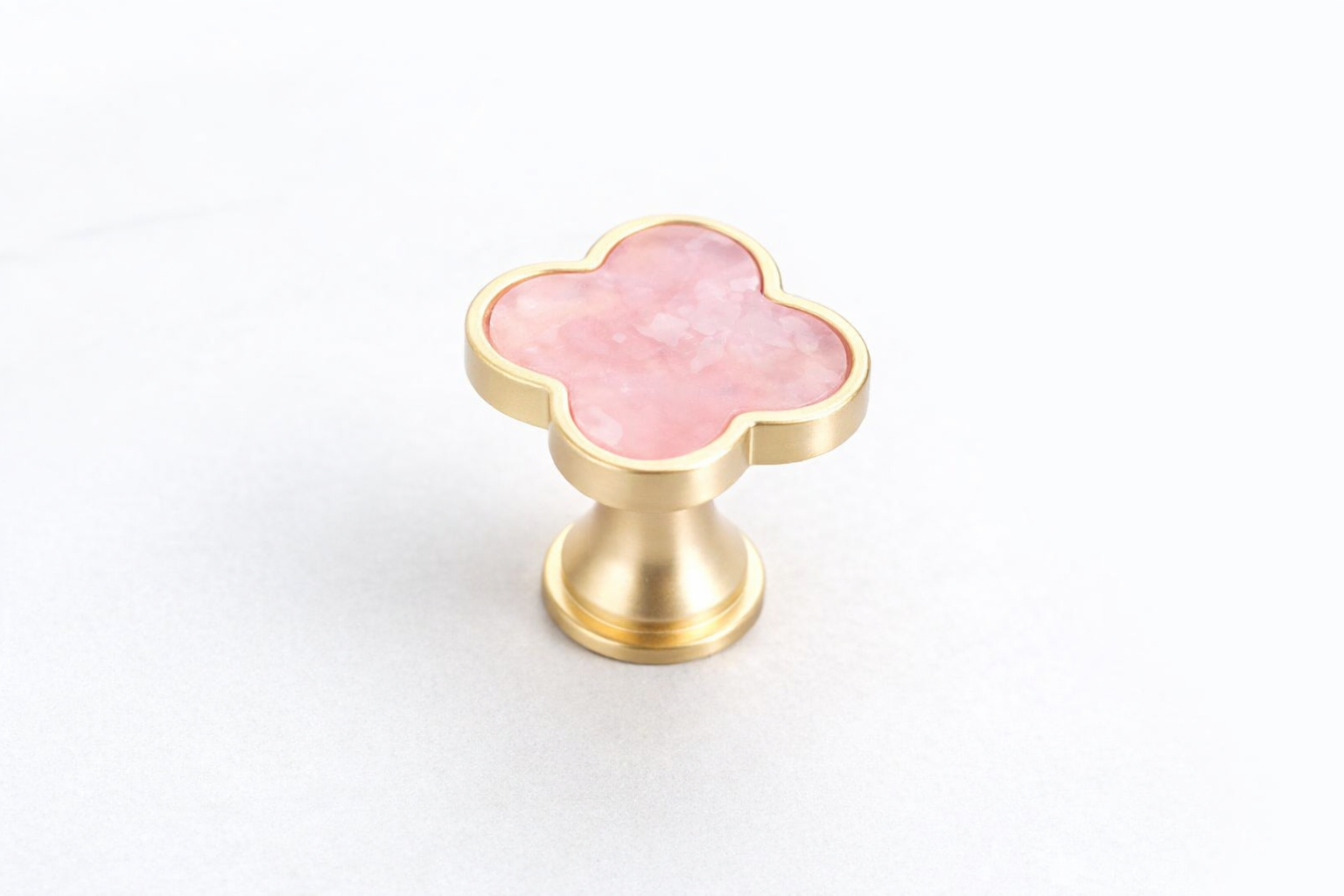 Clover-shaped cabinet knob featuring a stone-effect centre, brushed gold finish and durable zinc alloy construction for vanity drawers, wardrobes and furniture.