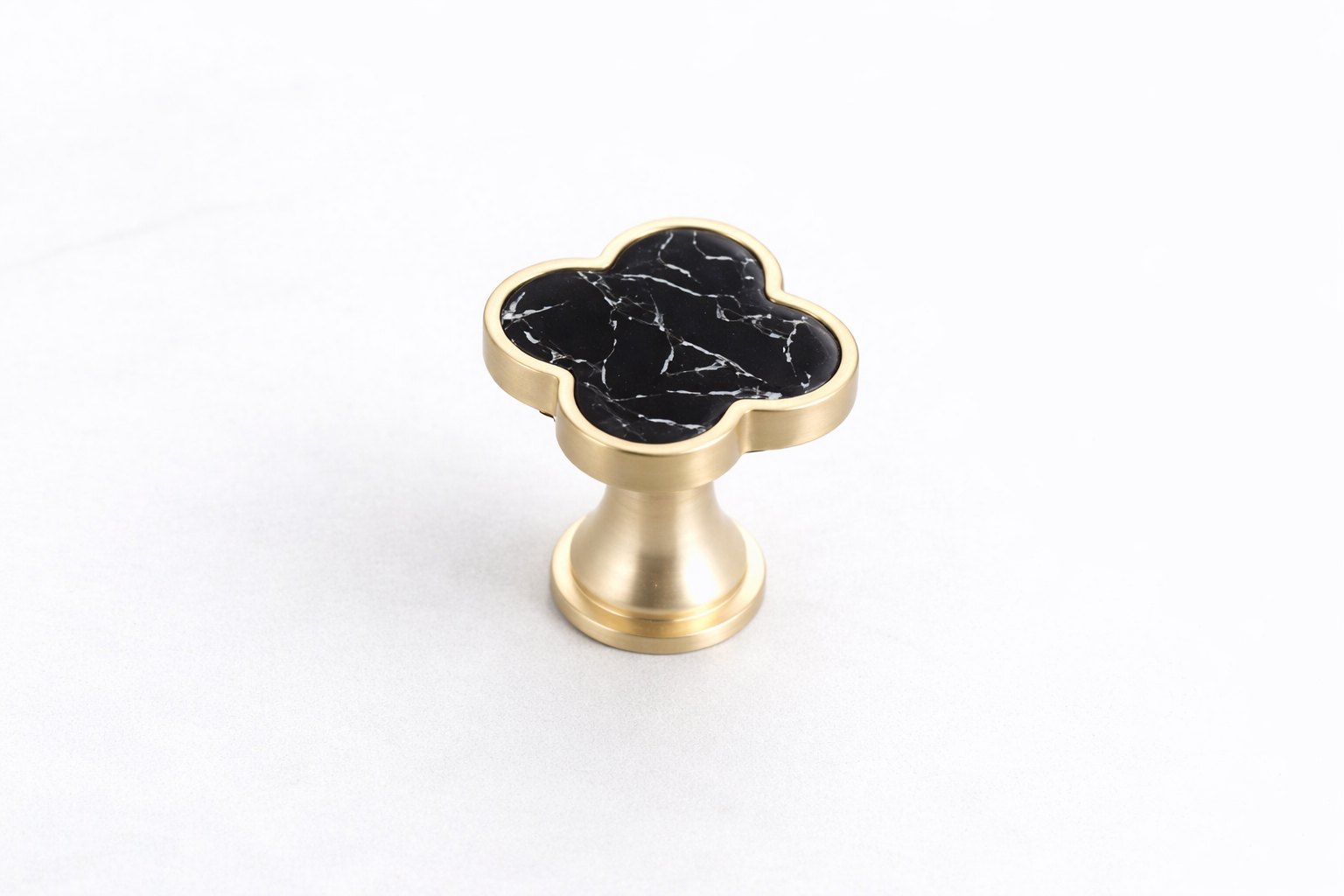 Decorative clover drawer knob with a textured stone-effect inlay and brushed gold frame, designed for luxury vanities, bedside tables and cabinetry.