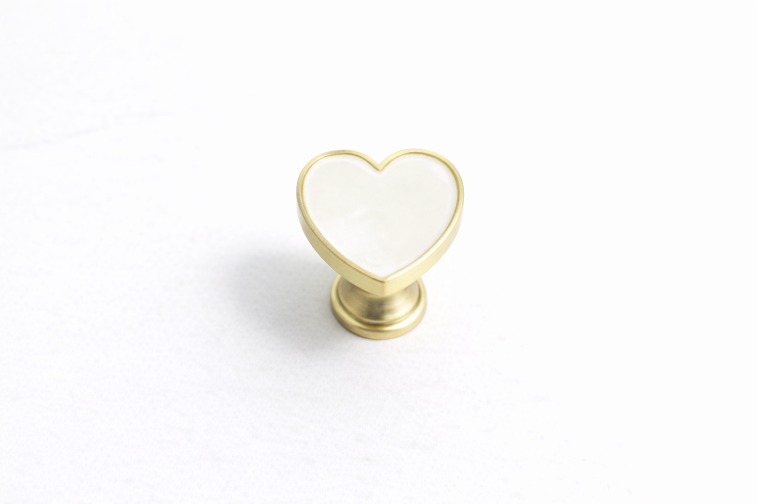 Heart-shaped cabinet knob featuring a stone-effect centre, brushed gold finish and durable zinc alloy construction for vanity drawers, wardrobes and furniture.