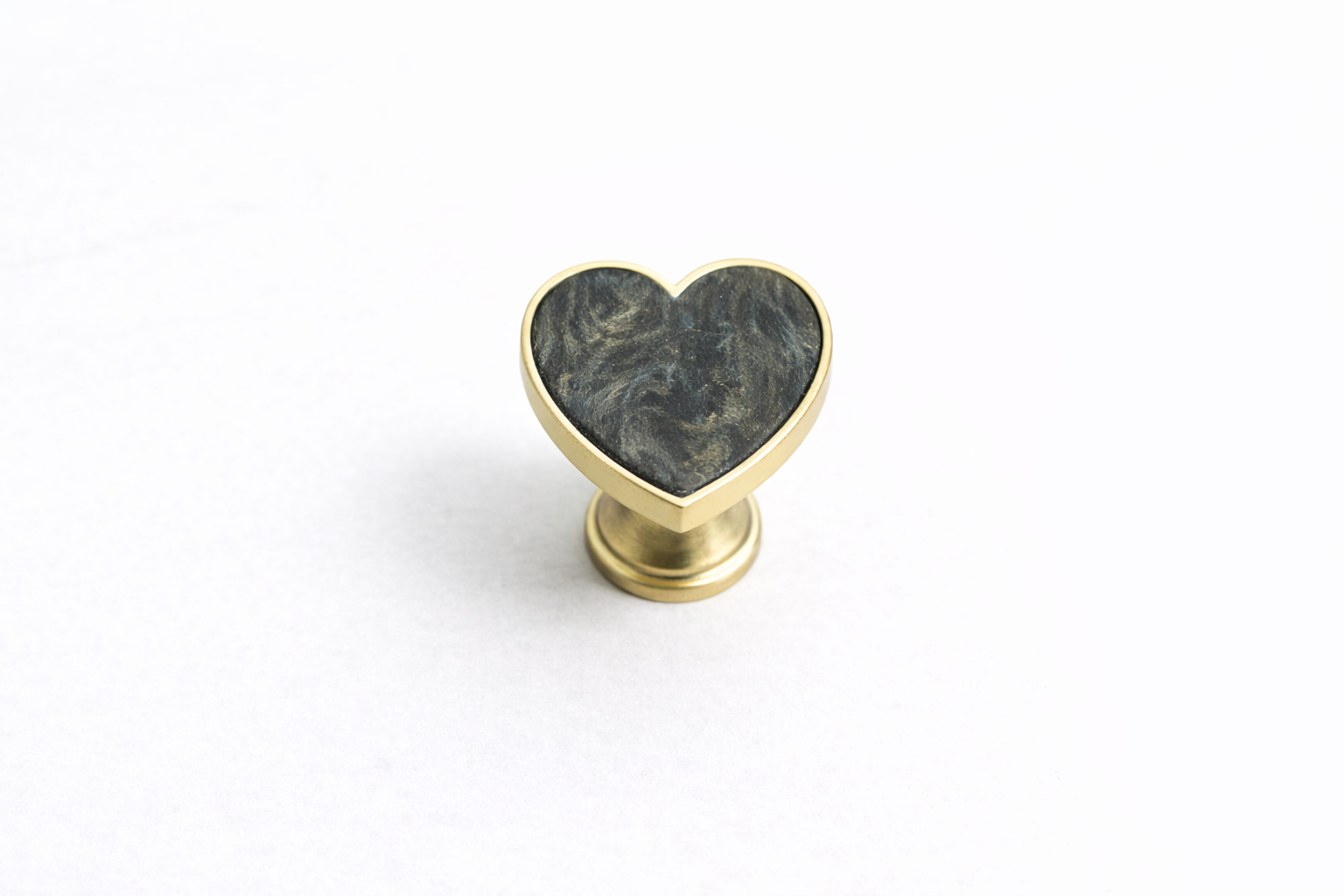Decorative heart-shaped drawer knob with a textured stone-effect inlay and brushed gold frame, designed for luxury vanities, bedside tables and cabinetry.