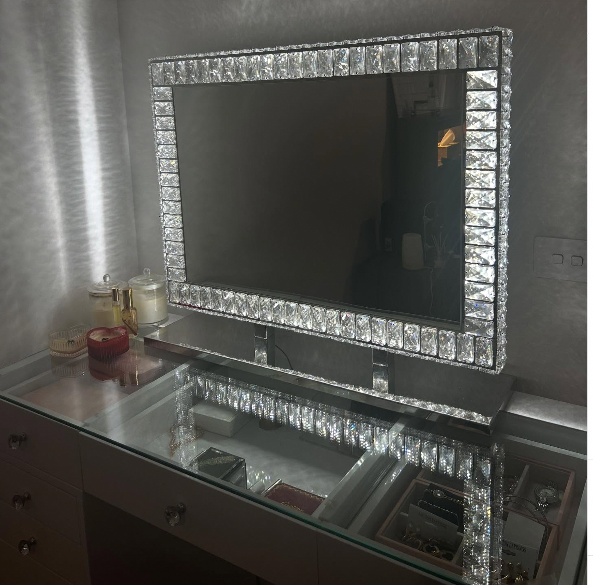 Luxury diamond Hollywood mirror with sparkling crystal detailing, soft LED illumination and an elegant mirrored base for glamorous makeup stations and beauty rooms.