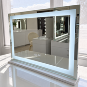 Mini Nova makeup mirror with illuminated rectangular LED border on a white vanity in the Vanity Vault showroom