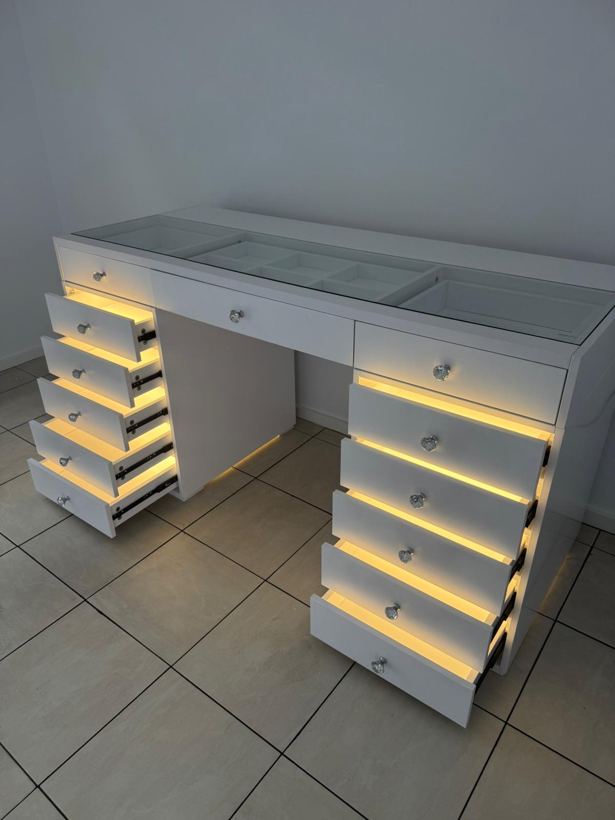 Professional makeup vanity station with LED-lit drawers, premium storage, flush glass top and a luxury high-gloss finish for beauty enthusiasts and content creators.