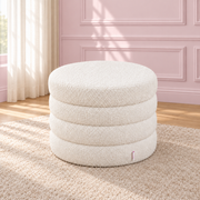 Vanilla Swirl white round storage ottoman with horizontal padded bands and a closed lid.
