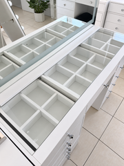 Angled close-up of the flush-fitted glass top, white border and clear crystal drawer knobs