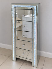 Winter Whisper mirrored tallboy with five drawers, clear crystal knobs and illuminated crushed-crystal trim in the showroom